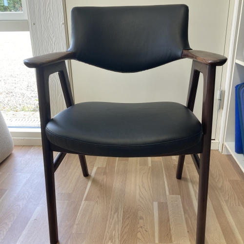 Ombetrækning af sort læder stol med teak.