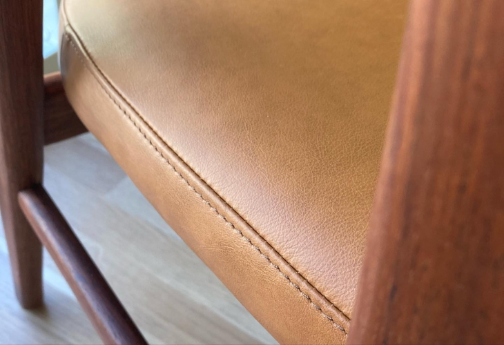 Close up af brun stol med brun læder ombetrækning.