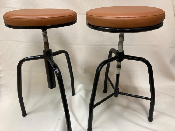 Ombetrækning af to barstole i sort og brun ved siden af hinanden.