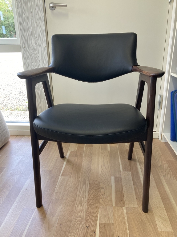 Ombetrækning af sort læder stol med teak.